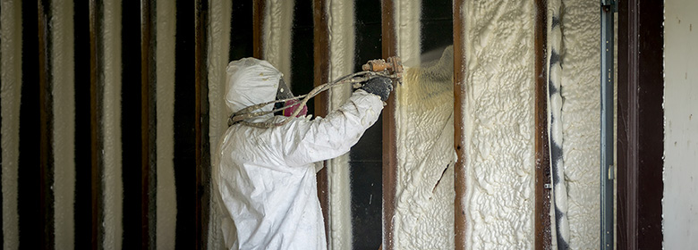 worker adding insulation to wall